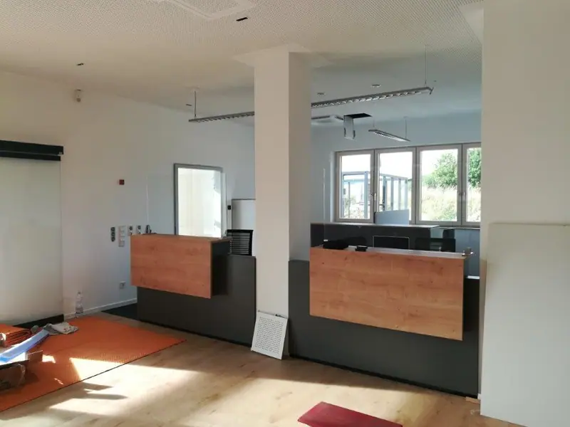 Empfangsbereich mit zwei Theken mit Holzfront in einem hellen Büro